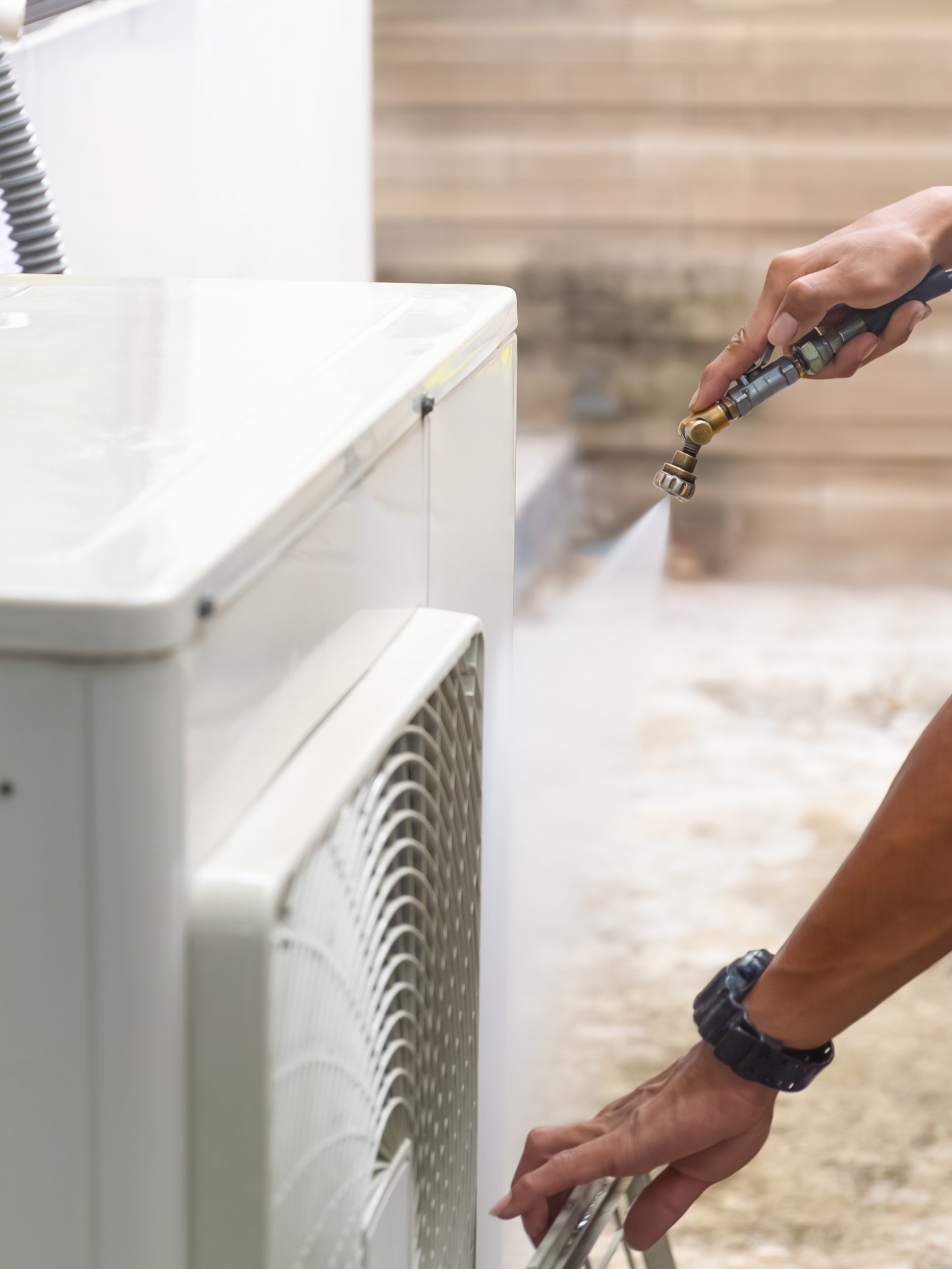 Condenser unit or compressor outside industrial plant building, part of central air conditioner (AC) or heating ventilation air conditioning system (HVAC) with electric fan and refrigerant pump inside